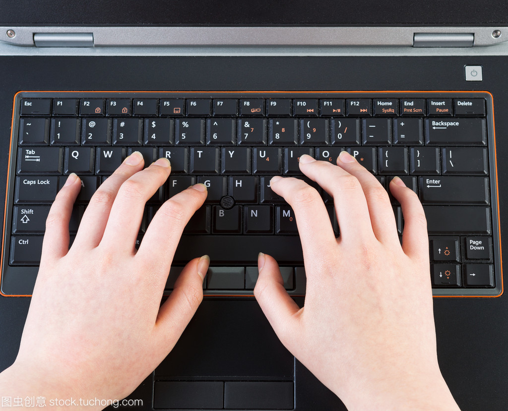 笔记本电脑键盘上打字的女性手